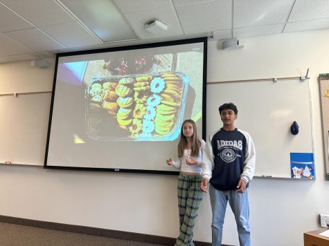 MENASA leaders Ellika LeSage 26 and Dhara Jobrani 26 explain the desserts on offer as displayed on the doc cam in a classroom at break on Tuesday, Sept. 27.