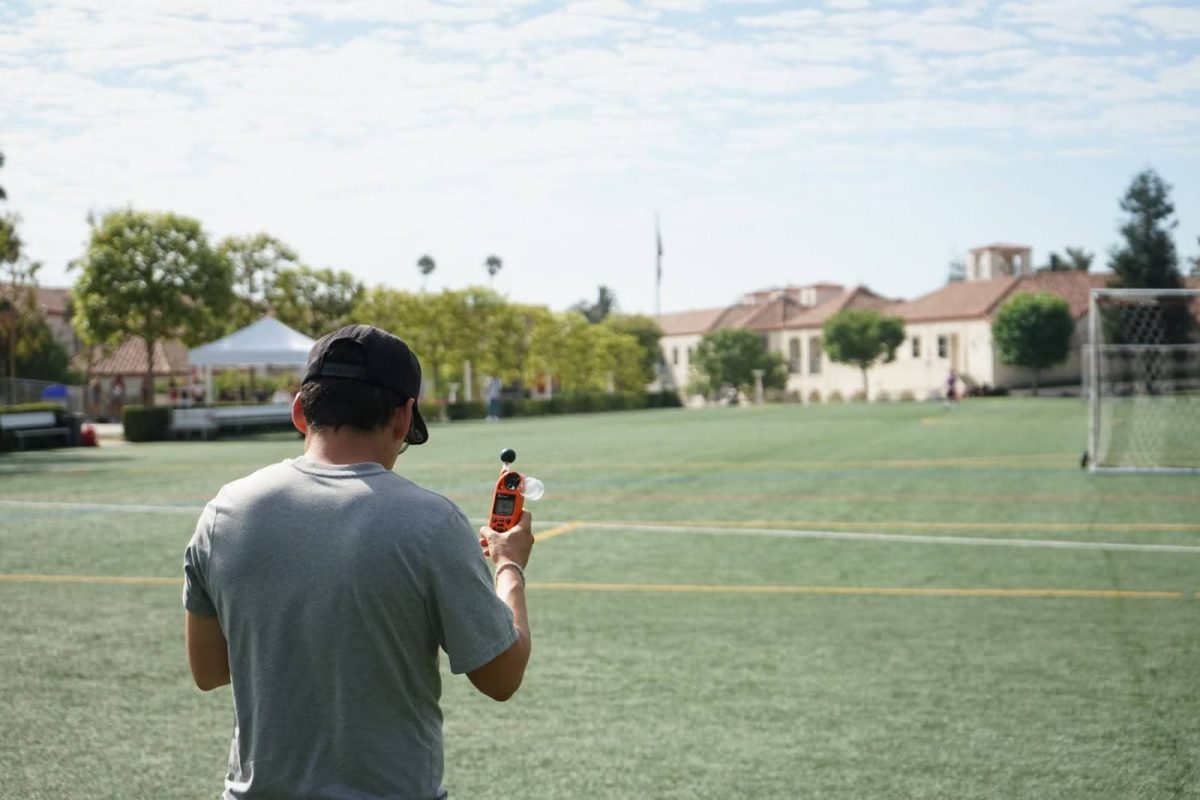 Athletic trainer Alex Calderon measures the heat index on Sprague Field with a wet-bulb thermometer. 