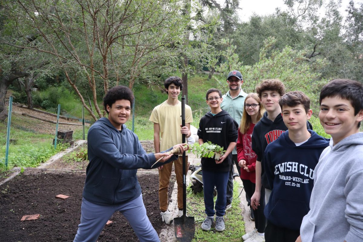 Gardening Club member Joseph Holly ’29 holds his parsnip plant next to other Jewish Club and Gardening Club members.