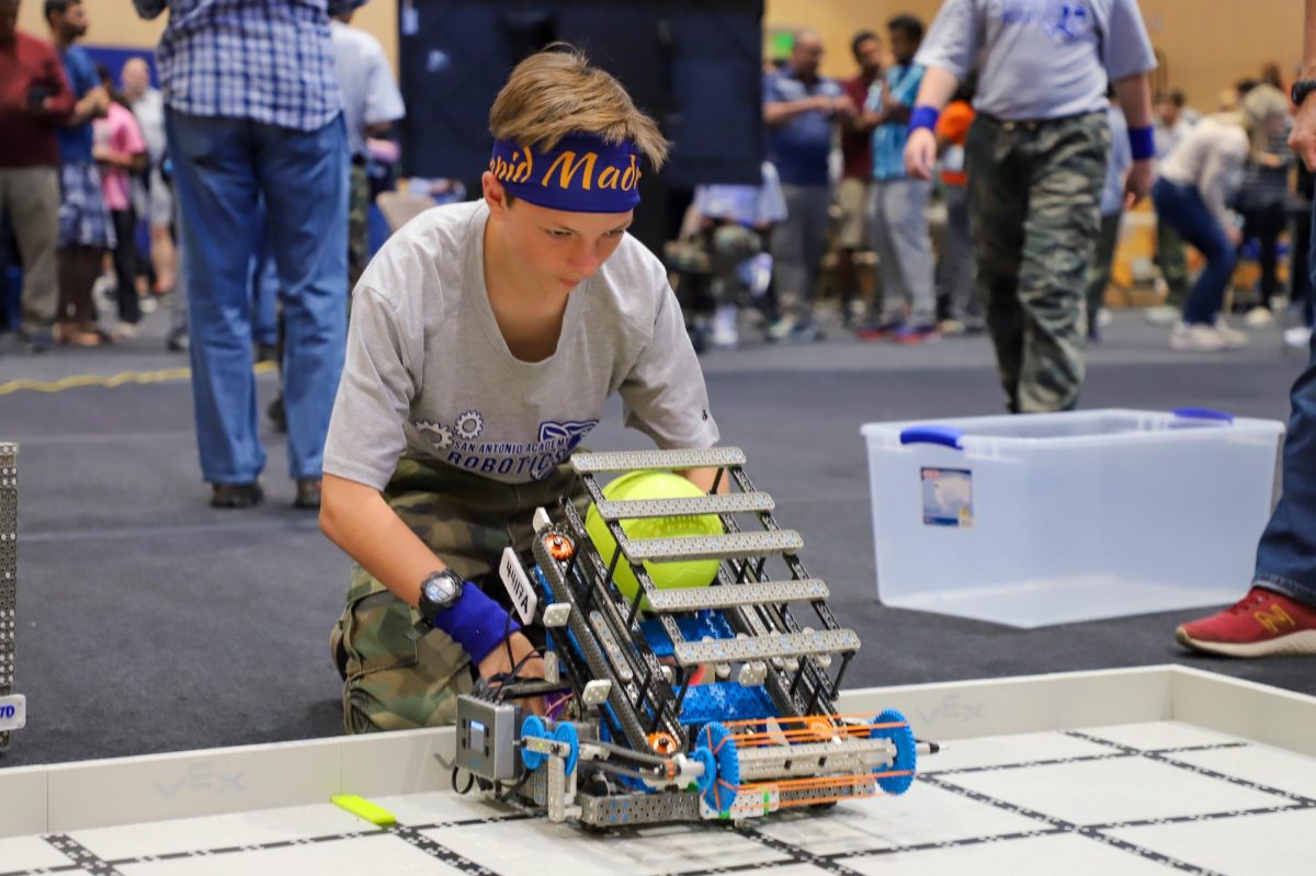 A competitor at the tournament checks up on the robot before their match.